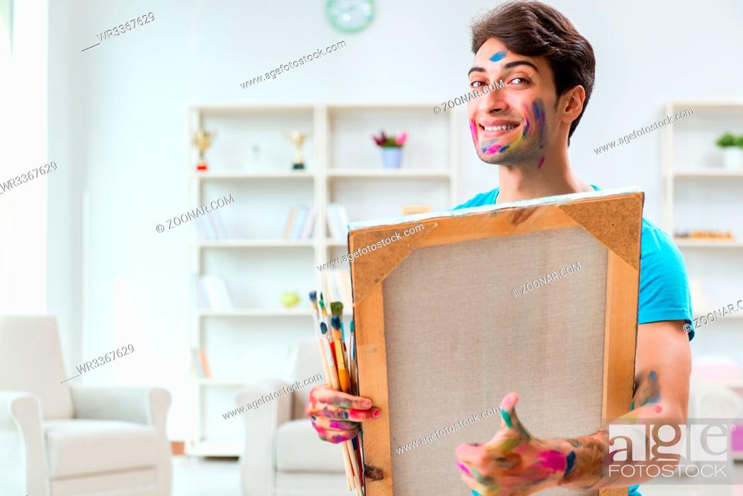 Imagen: Young funny artist working on new painting in his studio.