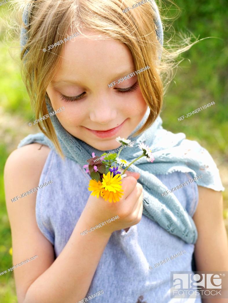 Imagen: Girl holding bunch of wild flowers.