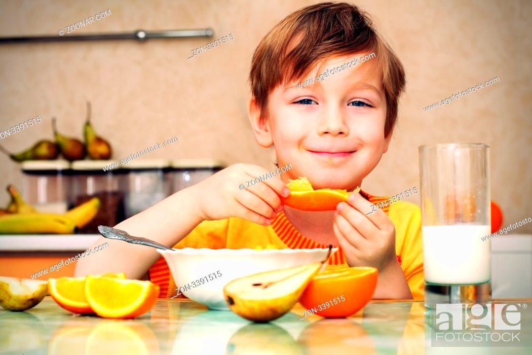 Stock Photo: boy, breakfast, drinks milk, eats cereal and orange.