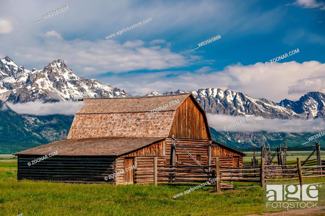 Stock Photo: Old mormon barn in Grand Teton Mountains with low clouds. Grand Teton National Park, Wyoming, USA.