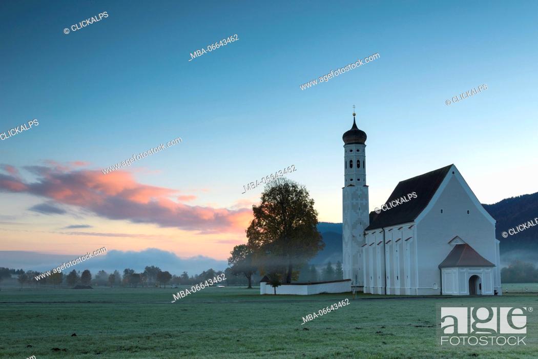 Stock Photo: Pink clouds at sunrise on St Coloman Church surrounded by woods Schwangau Bavaria Germany Europe.