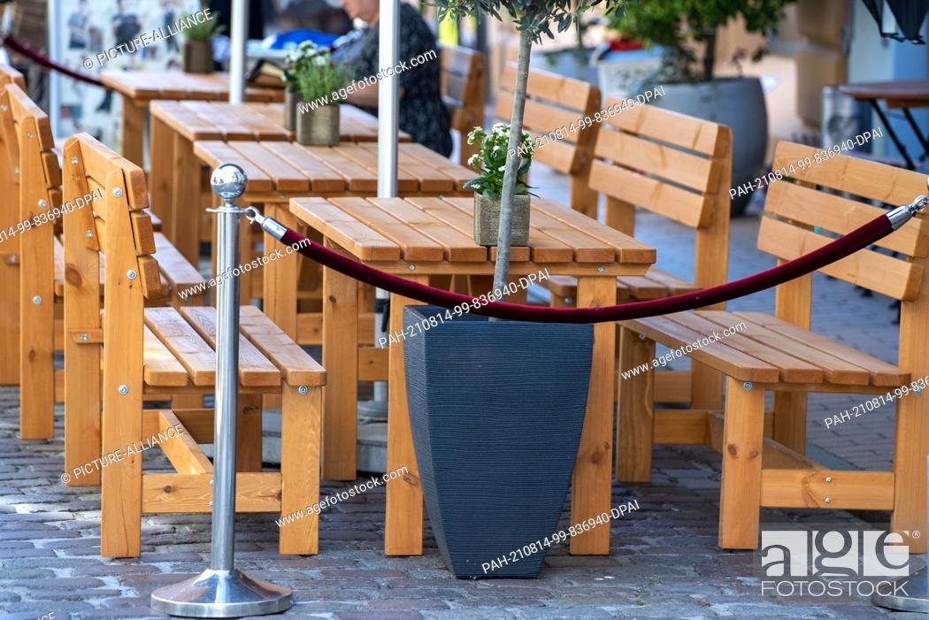 Stock Photo: PRODUCTION - 06 August 2021, Mecklenburg-Western Pomerania, Schwerin: Empty tables in front of a restaurant in the old town.