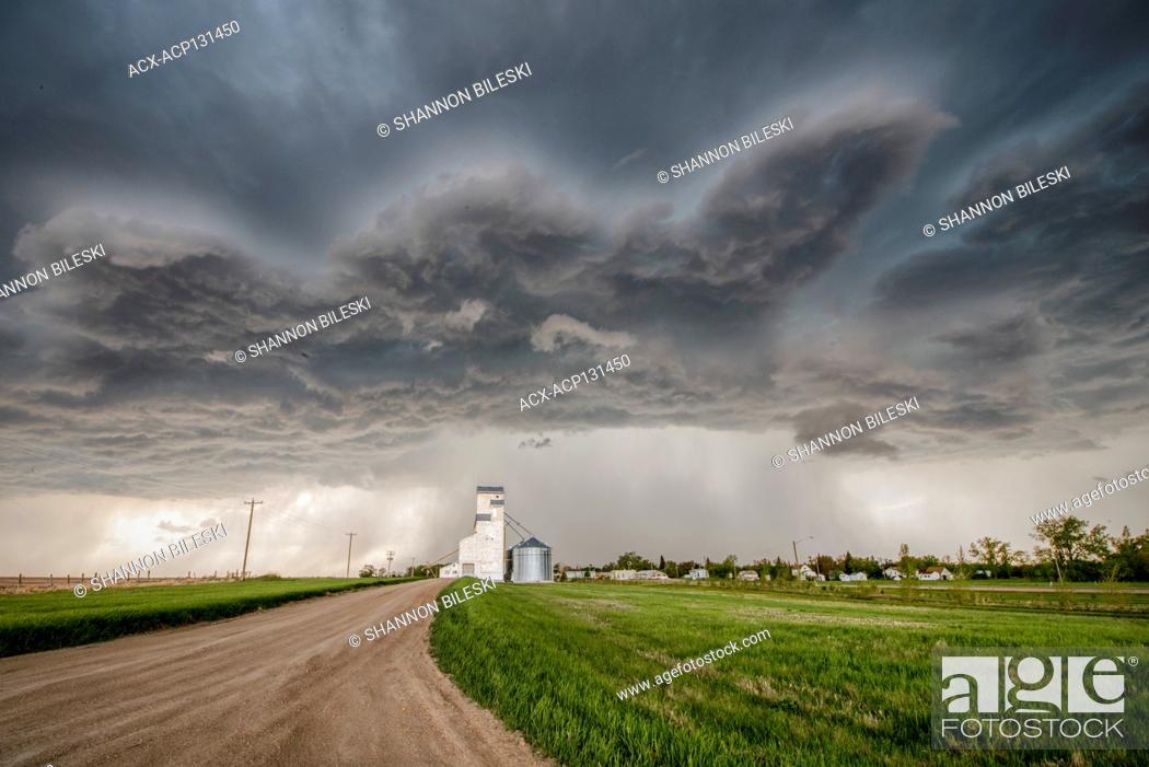 Stock Photo: Storm with gravel road over grainery in rural southern Manitoba Canada.