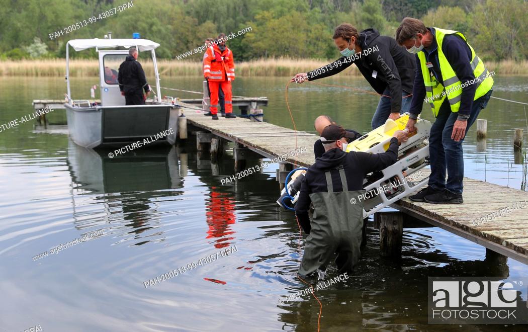Stock Photo: 13 May 2020, Saxony-Anhalt, Seegebiet Mansfelder Land: Members of a research group lift a diving robot with a high-resolution 3D laser into the sweet lake.