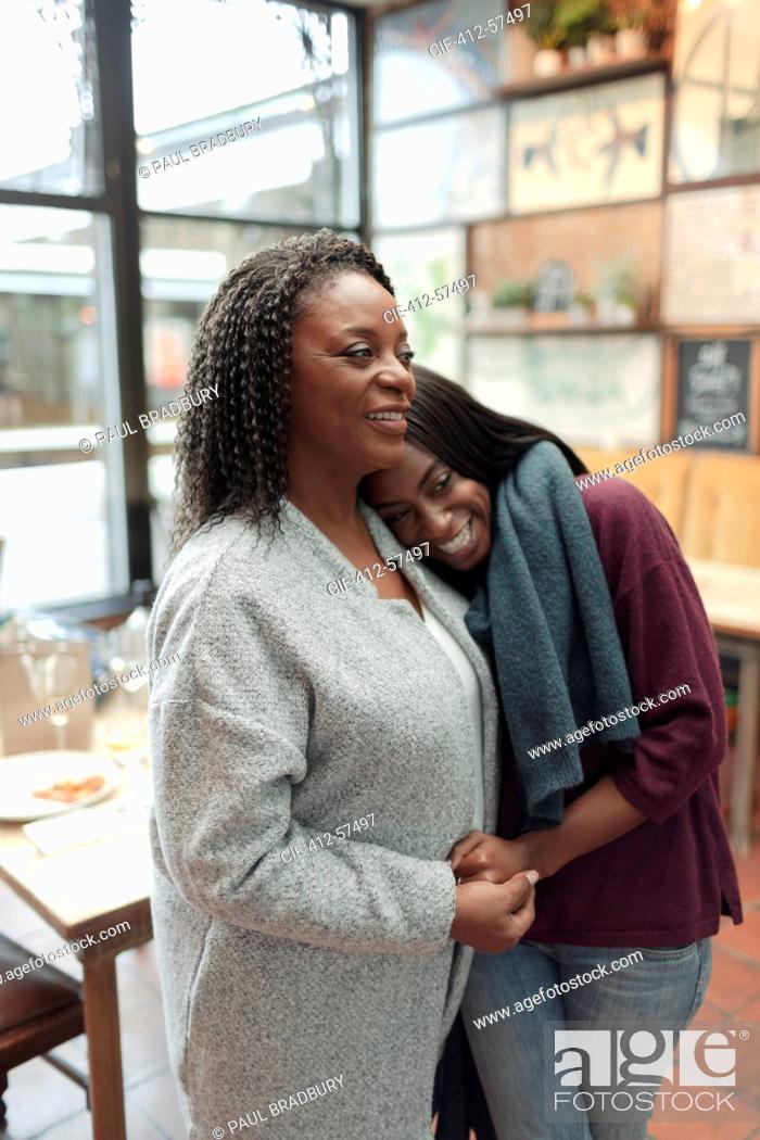 Photo de stock: Affectionate mother and daughter hugging in cafe.