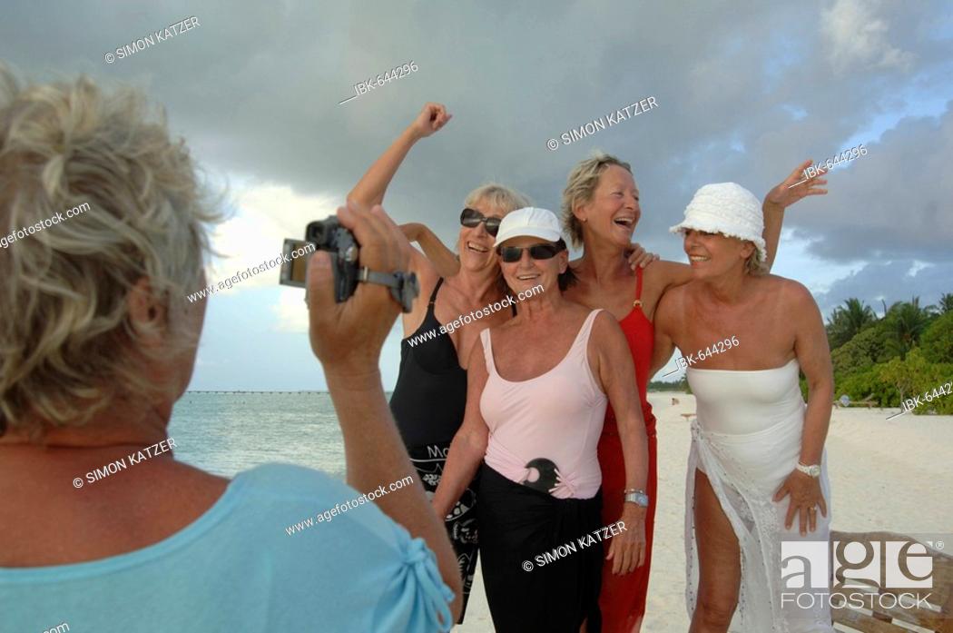 Photo de stock: Elderly women filming each other with a video camera on the beach, Diffushi Island, Holiday Island, Southern Ari Atoll, Maldives, Indian Ocean.