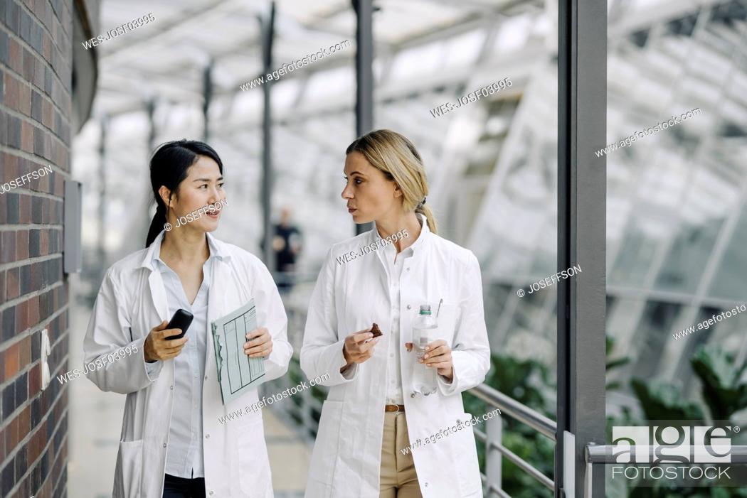 Stock Photo: Two female doctors talking in a modern building.