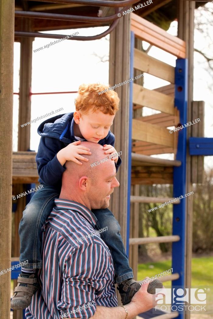 Stock Photo: Father carrying son on playground.