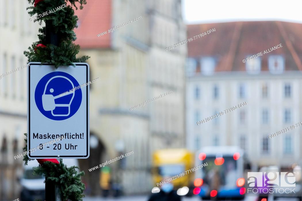 Stock Photo: 21 December 2020, North Rhine-Westphalia, Münster: A sign indicates that masks are compulsory at Prinzipalmarkt. Photo: Rolf Vennenbernd/dpa.