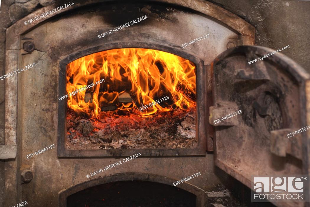Stock Photo: Fire wood in ancient rust stove.