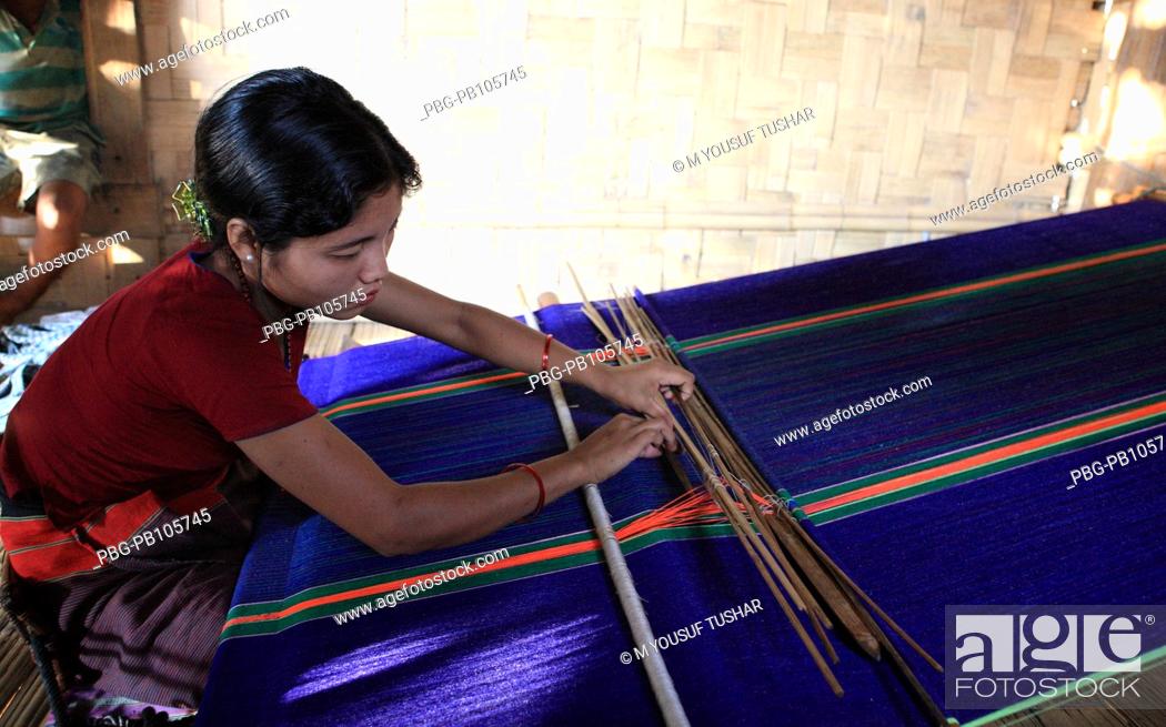 Stock Photo: A Marma tribal woman weaving cloth on traditional handloom Bandarban, Bangladesh December 2009.