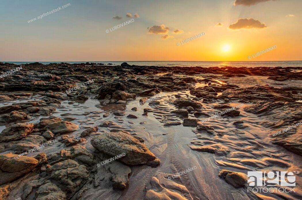 Stock Photo: Beach in golden sunset light during low tide showing sand formations and wet stones not covered by the sea. Kantiang Bay, Ko Lanta, Thailand.