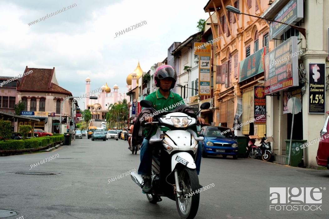 Stock Photo: A man is riding a motorbike in Kuching, Malaysia, 21 October 2014. Photo: Sebastian Kahnert - NO WIRE SERVICE - | usage worldwide.