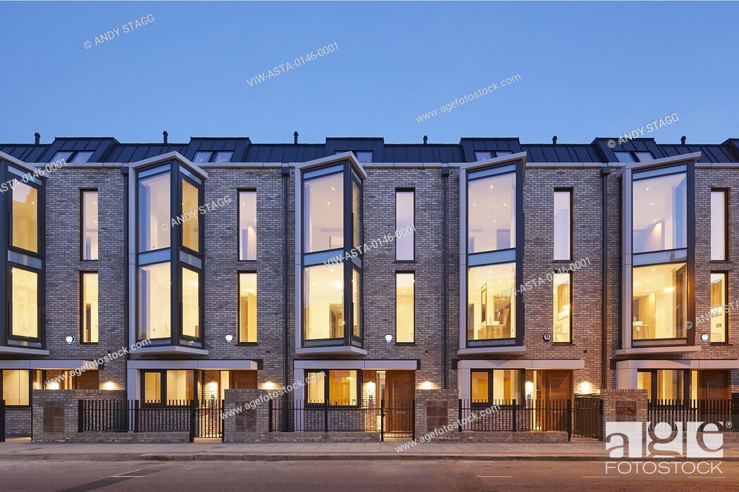 Stock Photo: Front elevation of modern terrace with lit interiors. Warriner Gardens, London, United Kingdom. Architect: Child Graddon Lewis , 2019.
