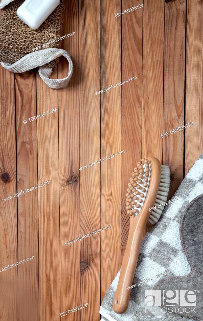 Stock Photo: Accessories for visiting a bath or sauna on a wooden background: towel, washcloth, massage brush, soap, glove. Top view with copy space. Flat lay.