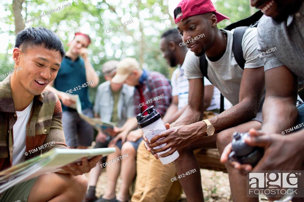 Stock Photo: Men friends looking at hiking map in woods.