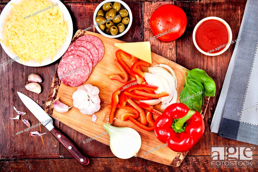 Stock Photo: Ingredients, cheese, vegetables prepared for homemade pizza, on wooden board on the table. View from above.