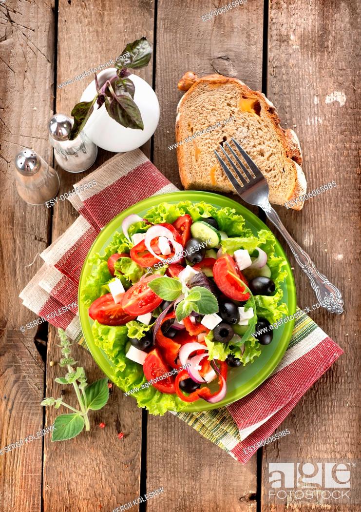 Stock Photo: Tasty vegetable salad on a wooden background.