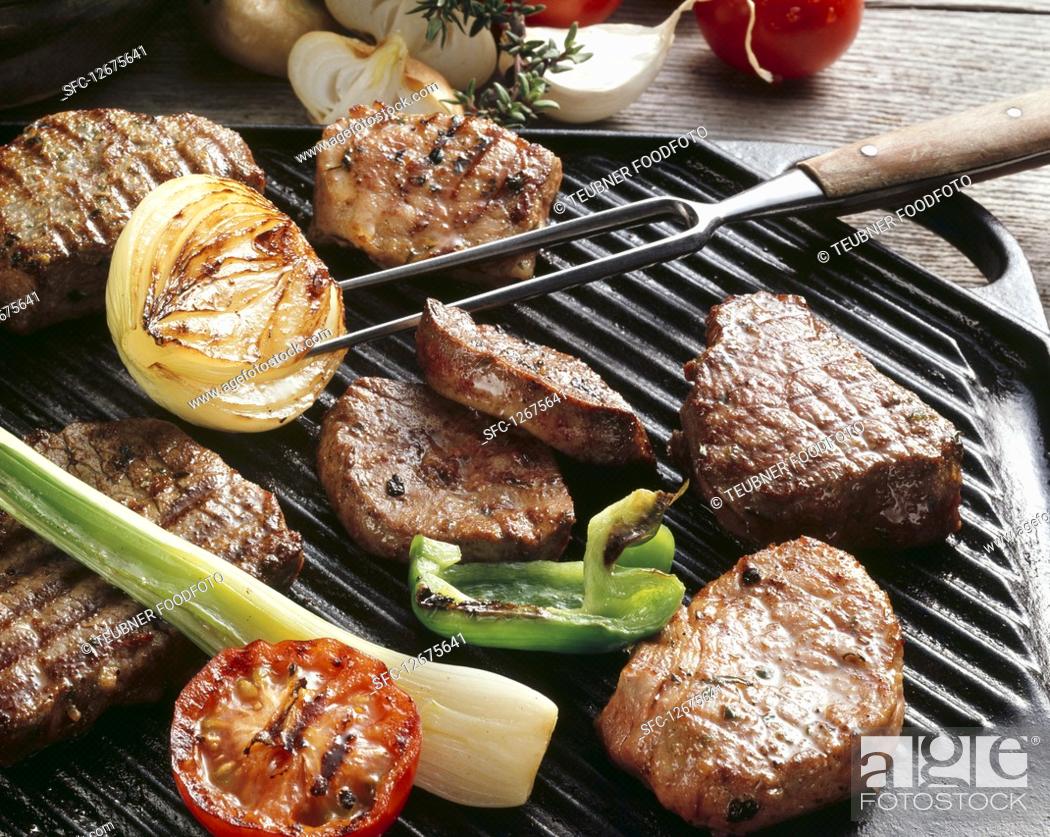 Stock Photo: Various meats and vegetables on a grill.