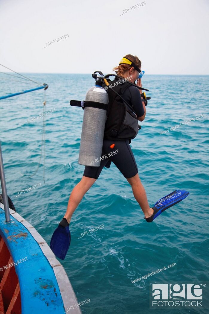 Stock Photo: female scuba diver jumps in water, koh tao, thailand.