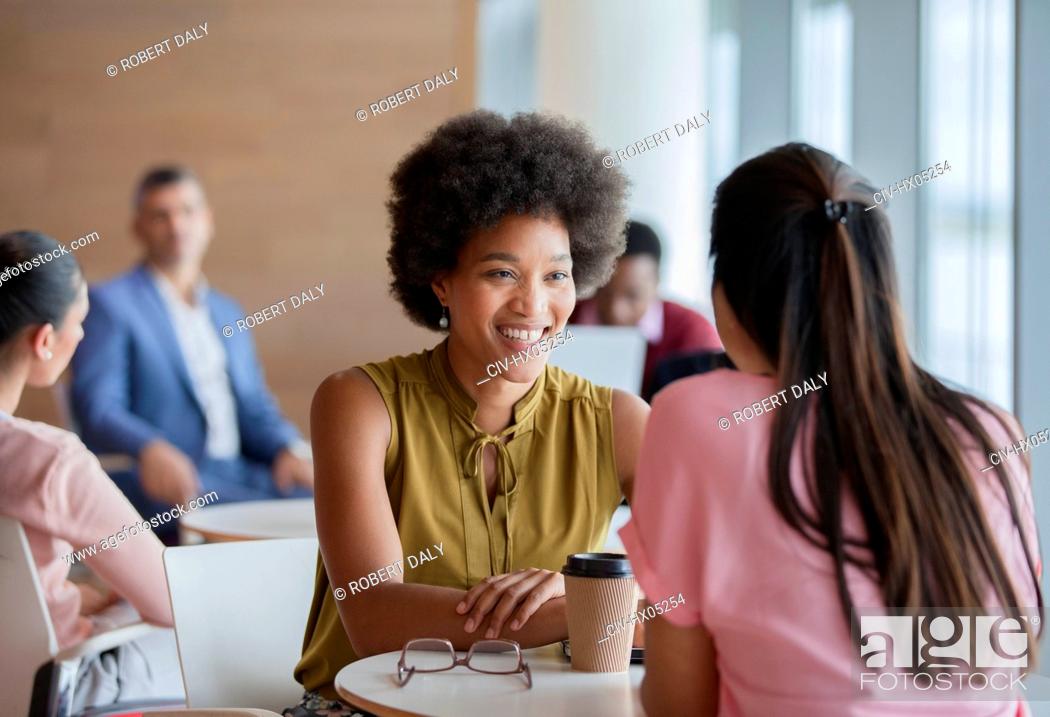 Stock Photo: Smiling businesswomen enjoying coffee break.