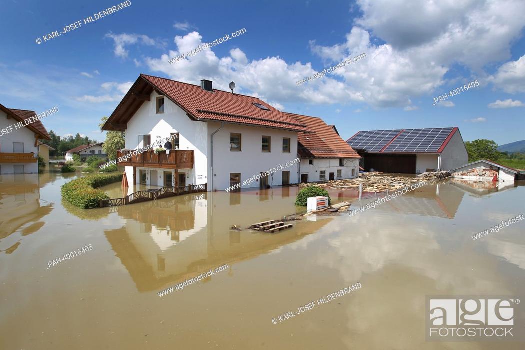 Stock Photo: Local residents stand on a balcony of a residential building observing the surrounding area submerged in the floodwater in Deggendorf, Germany, 5 June 2013.