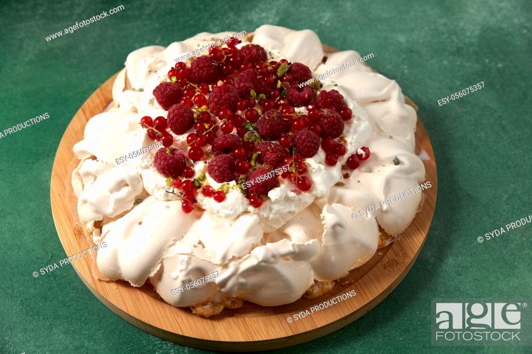 Stock Photo: pavlova meringue cake with berries on wooden board.