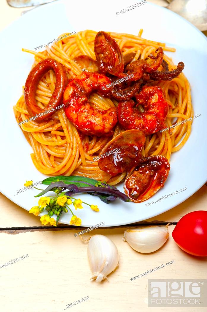 Stock Photo: Italian seafood spaghetti pasta on red tomato sauce over white rustic wood table.