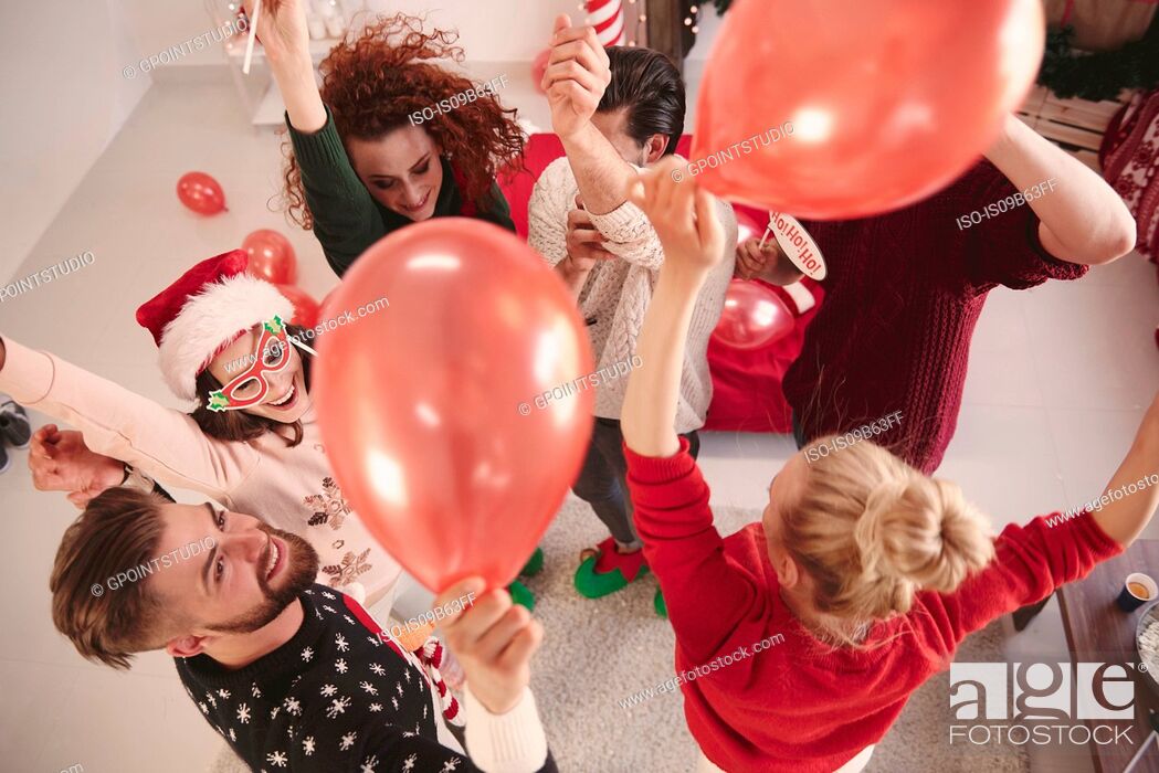 Stock Photo: Overhead view of young adult friends dancing with balloons at christmas party.