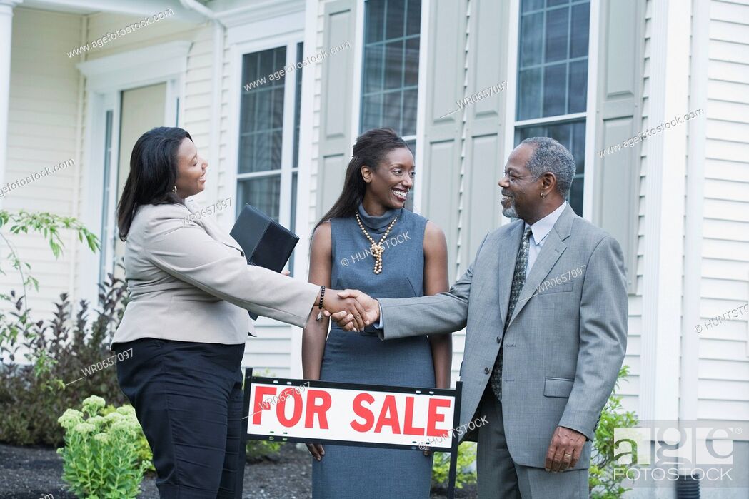 Stock Photo: Middle-aged man shaking hand with a real estate agent and a middle-aged woman looking at him.