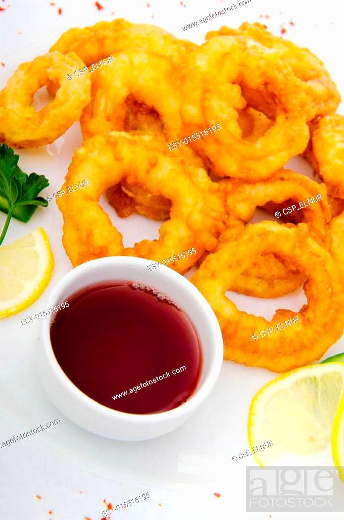 Stock Photo: Fried calamari rings served with sauce.