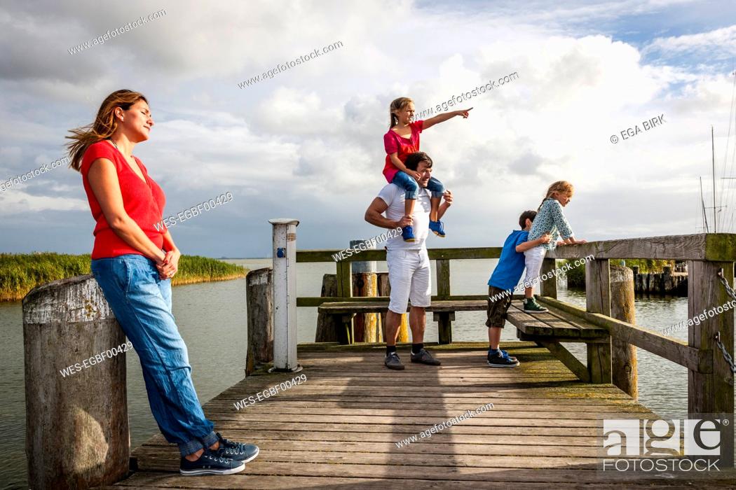 Stock Photo: Family standing on a pier looking at view, Ahrenshoop, Mecklenburg-Western Pomerania, Germany.
