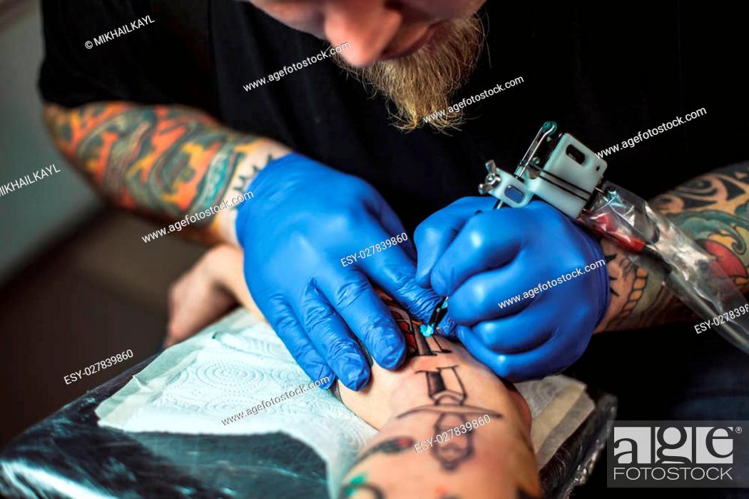 master tattoo artist with a beard makes gloves tattoo on hand men, Stock  Photo, Picture And Low Budget Royalty Free Image. Pic. ESY-027839860 |  agefotostock