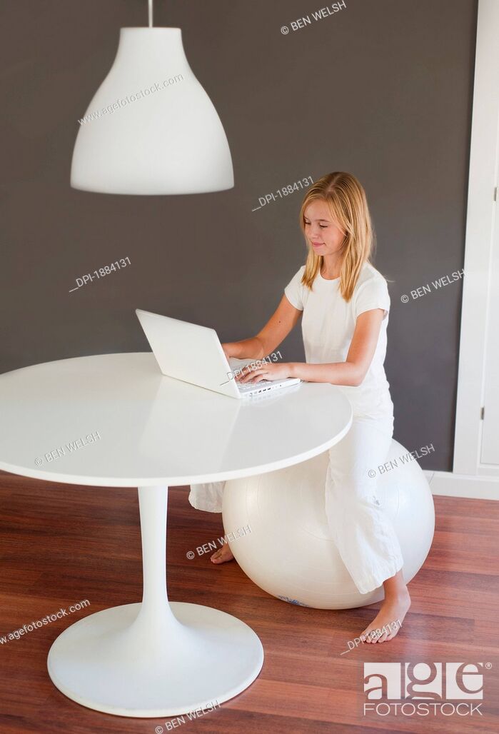 Imagen: a girl wearing white using a white laptop computer in a room furnished in white, benalamadena costa, malaga, andalusia, spain.