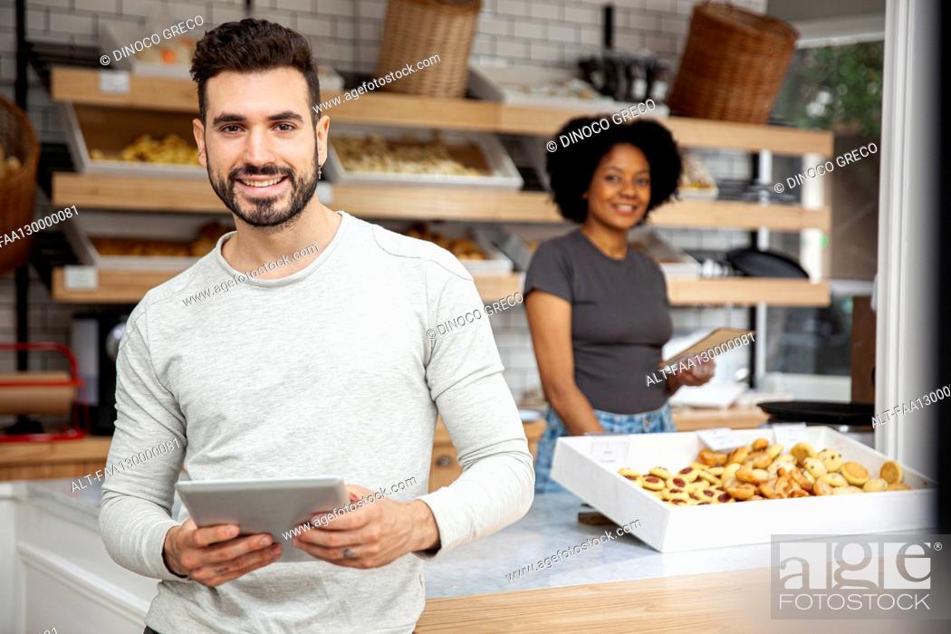 Stock Photo: Bakery owner holding digital tablet while looking at the camera.