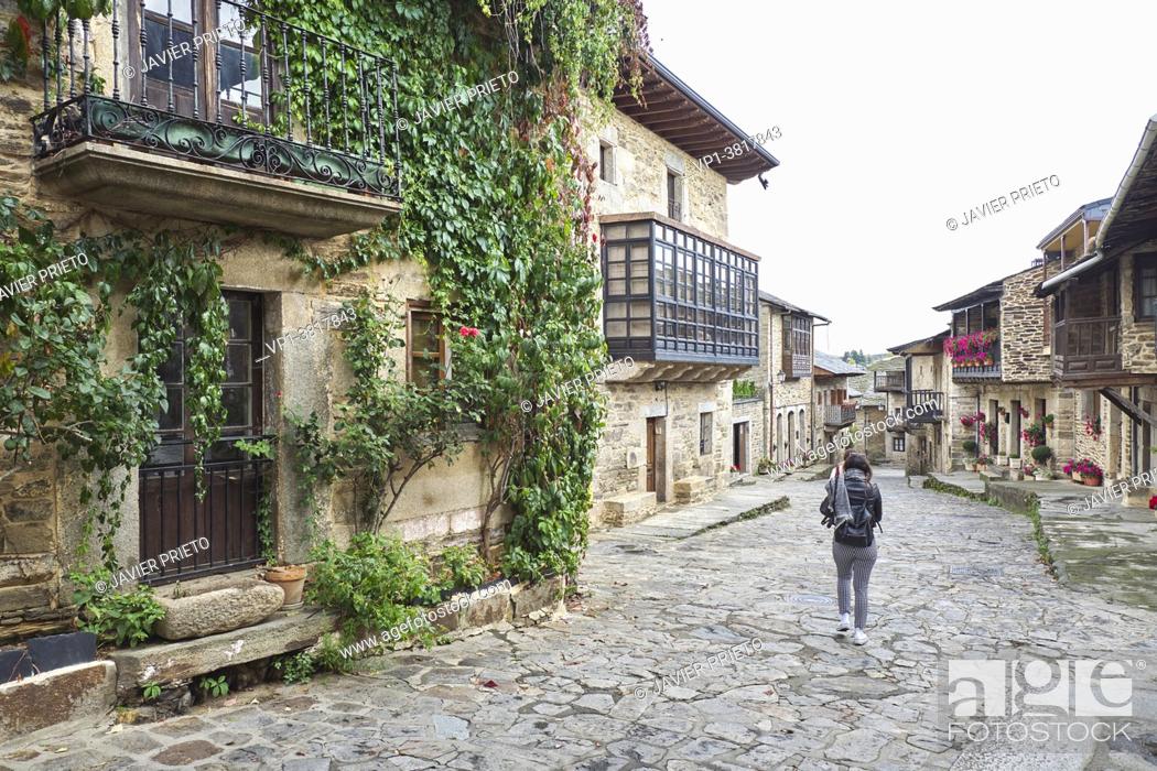 Stock Photo: A woman with her back turned walk through the streets of the historic center of Puebla de Sanabria. Zamora. Castile and Leon. Spain.