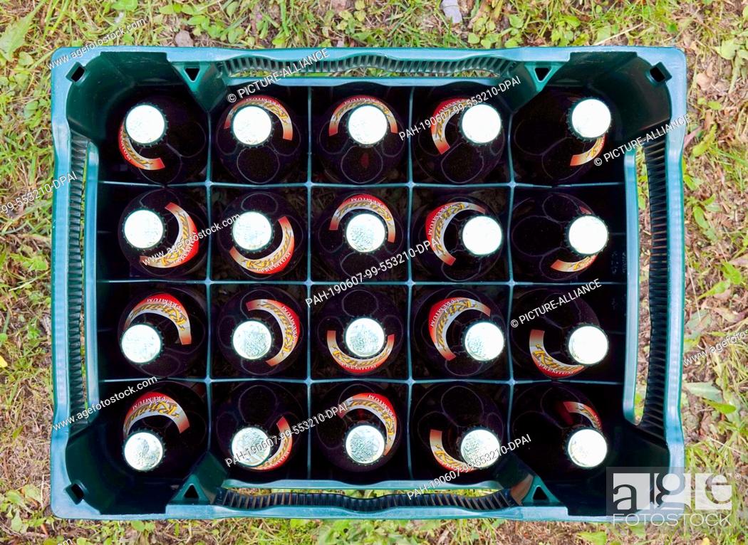 Stock Photo: 29 May 2019, Germany (German), Zella-Mehlis: A case of Rhöner Land Premium Pils beer stands on a meadow. Photo: Soeren Stache/dpa-Zentralbild/ZB.