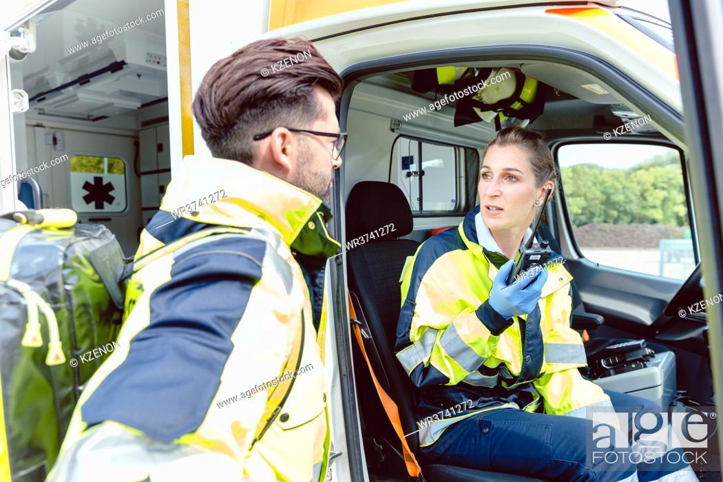Stock Photo: Paramedics in ambulance in radio contact with headquarters discussion deployment.