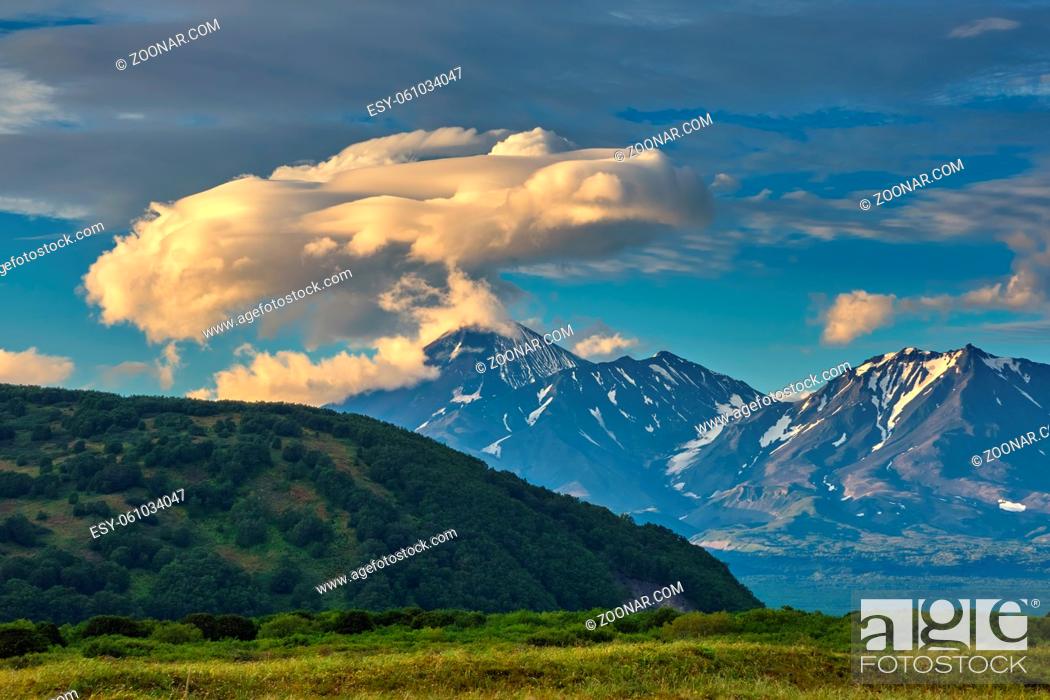 Stock Photo: Dramatic spectacular lenticular cloud formation over volcano on Kamchatka peninsula, Russia.