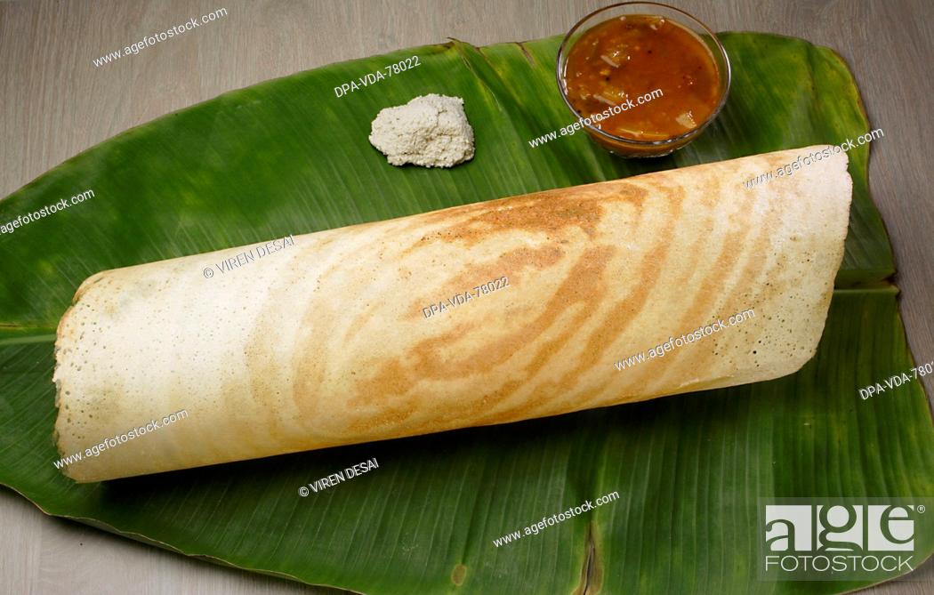Stock Photo: Indian snack food dosa with chutney and sambhar on a coconut leaf.