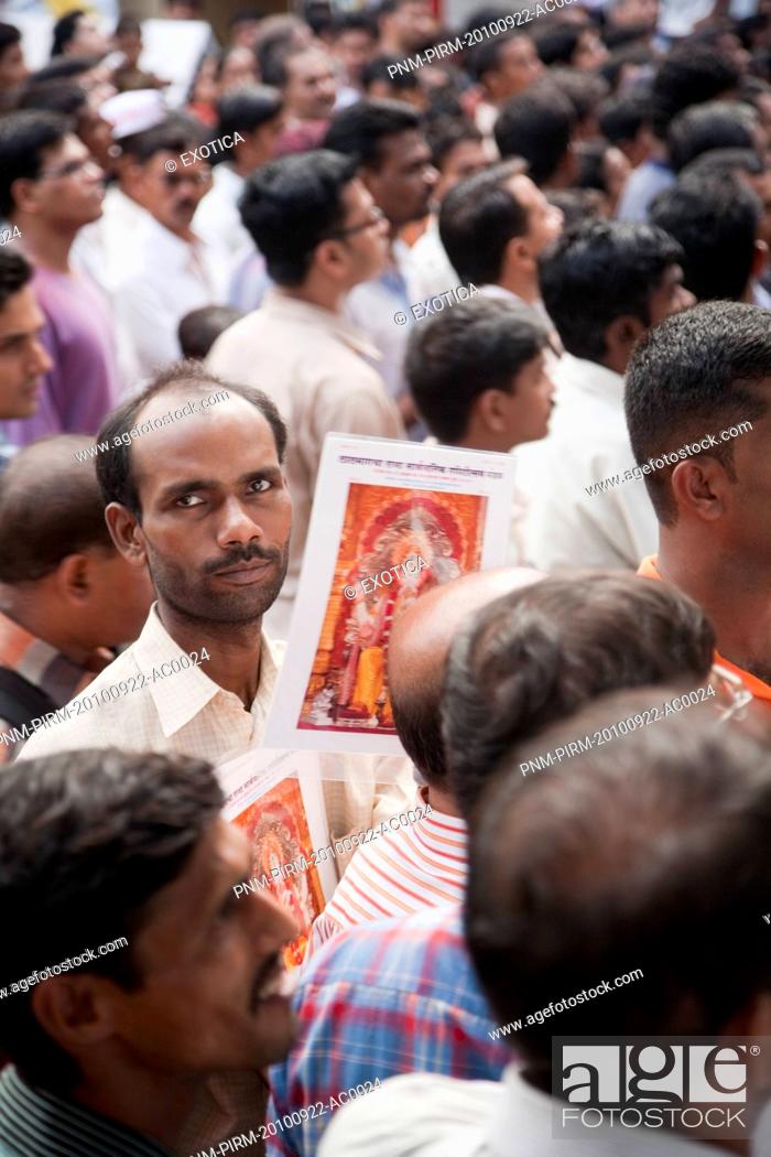 Stock Photo: Hawker selling posters of Lord Ganesha at a religious procession, Mumbai, Maharashtra, India.