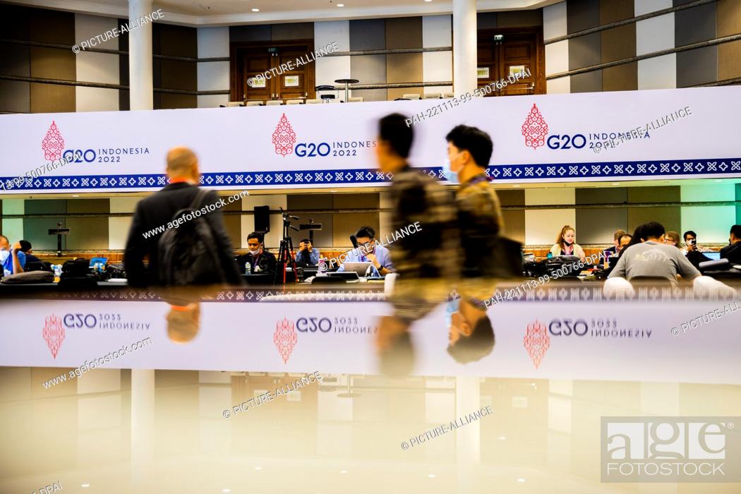 Stock Photo: 13 November 2022, Indonesia, Nusa Dua: People walk through the media center of the G20 summit. The meeting of the G20 group.