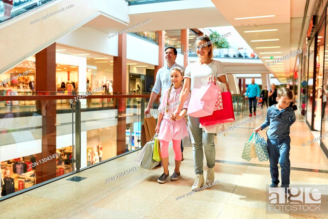 Stock Photo: Glückliche Familie beim Shopping mit vielen Einkaufstüten im Einkaufszentrum.