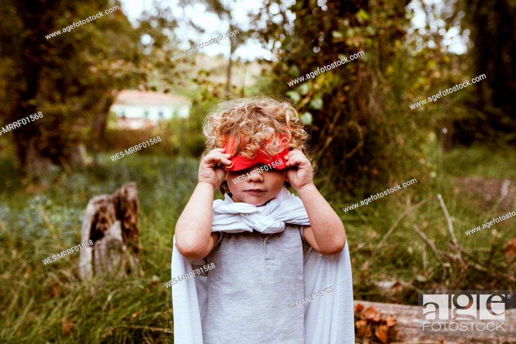 Boy with blond curly hair removing mask in forest, Stock Photo, Picture And  Royalty Free Image. Pic. WES-MRRF01568 | agefotostock