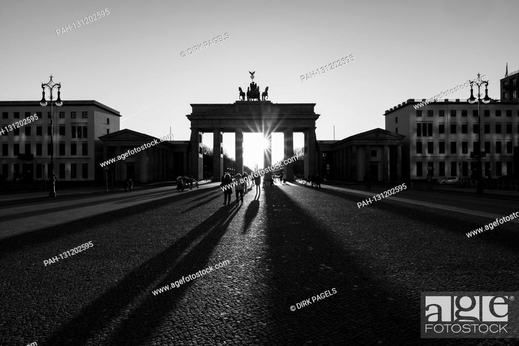 Stock Photo: 22.03.2020, the Brandenburg goal in Berlin on a late spring juice day in the low sun. The sun shines through the prophylaxis and creates a special mood of light.