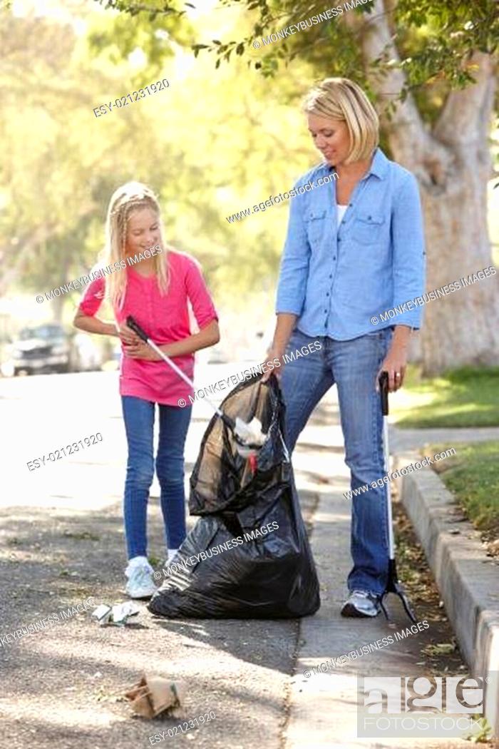 Stock Photo: Mother And Daughter Picking Up Litter In Suburban Street.