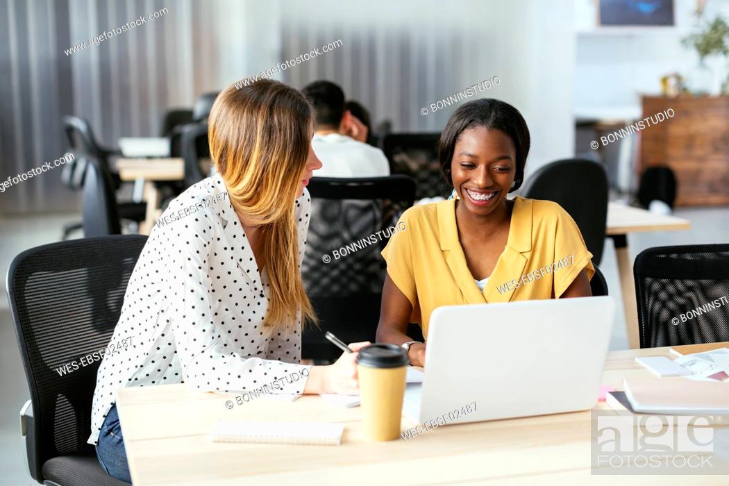 Stock Photo: Colleagues working together at desk in office.