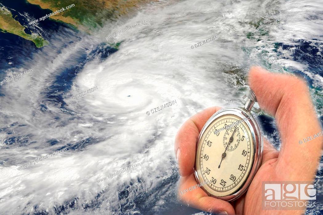 Stock Photo: Hurricane Patricia and Hand Holding old Stopwatch. Concept of Climate change. Elements of this image furnished by NASA.