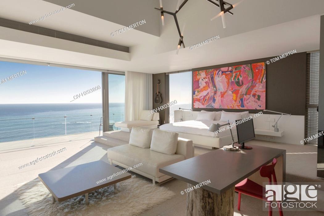 Stock Photo: Modern, luxury home showcase bedroom with sunny ocean view.