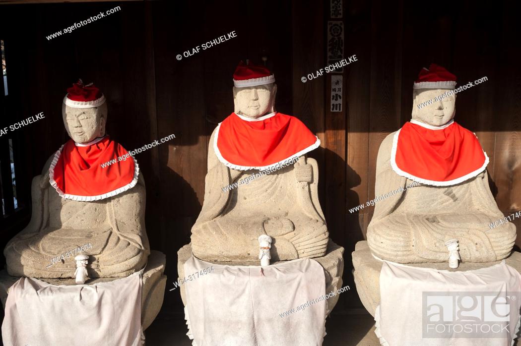Stock Photo: Takayama, Gifu, Japan, Asia - A row of Jizo statues made of stone, wearing red hats and bibs is seen sitting under a wooden shelter at the Hida Kokubun-ji.